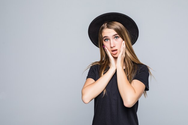 Beautiful losted young woman model shows emotions dressed up in dark clothes isolated on gray background