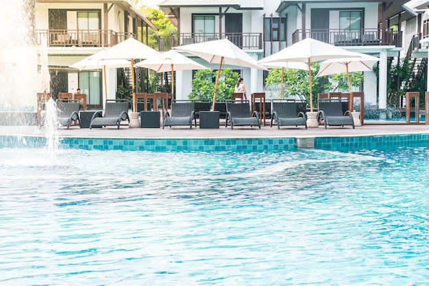 우산과 의자가있는 아름다운 고급 호텔 수영장 리조트