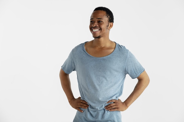 Красивый мужской поясной портрет, изолированные на белой стене. молодой эмоциональный афро-американский мужчина в голубой рубашке. выражение лица, человеческие эмоции, концепция рекламы. стою и улыбаюсь.