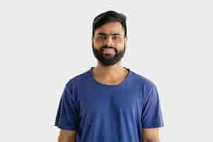 Free photo beautiful male half-length portrait isolated on white studio background. young emotional hindu man in blue shirt. facial expression, human emotions, advertising concept. standing and smiling.