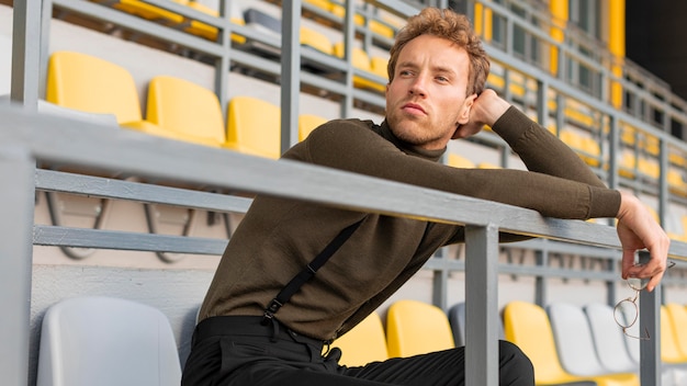 경기장에 앉아 아름 다운 남성 모델