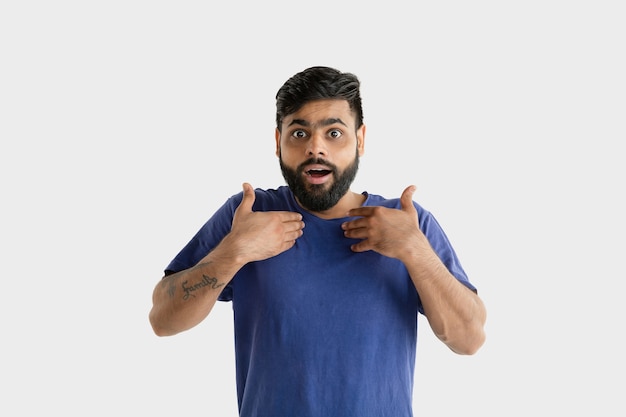 Beautiful male portrait isolated. Young emotional hindu man in blue shirt. Astonished, shocked, crazy happy.