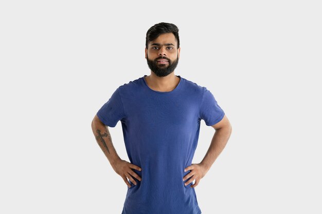 Beautiful male portrait isolated. Young emotional hindu man in blue shirt. Facial expression, human emotions. Standing and smiling.