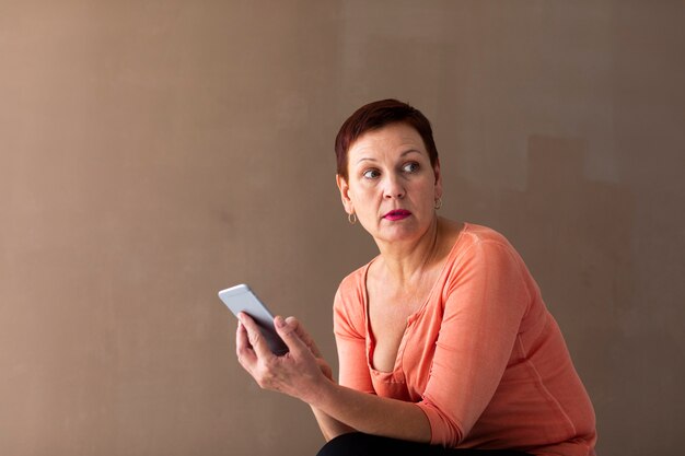 Beautiful mature woman holding phone