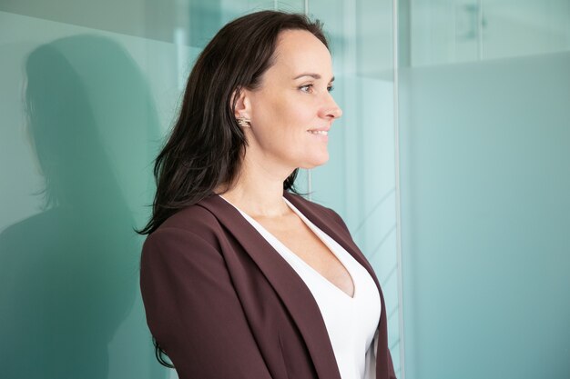 Beautiful middle-aged businesswoman standing and looking away