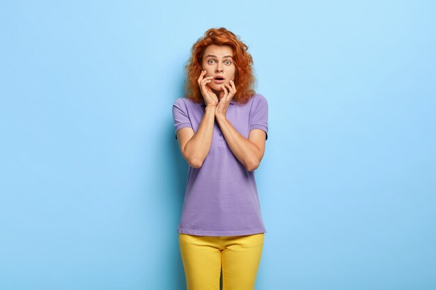 beautiful millennial woman with wavy red hair posing