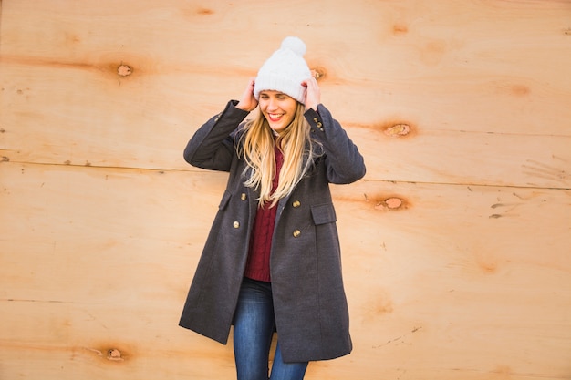 Beautiful model adjusting hat and smiling