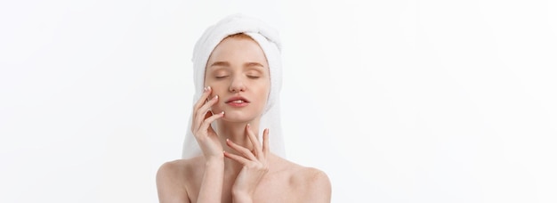 Free photo beautiful model applying cosmetic cream treatment on her face on white