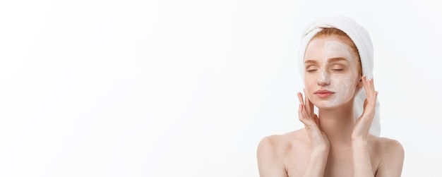 Foto gratuita bello modello che applica trattamento cosmetico crema sul suo viso su bianco