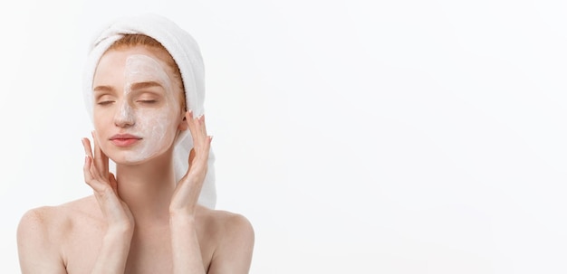 Foto gratuita bello modello che applica trattamento cosmetico crema sul suo viso su bianco