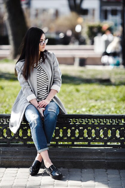 Beautiful model in glasses sit on the fence