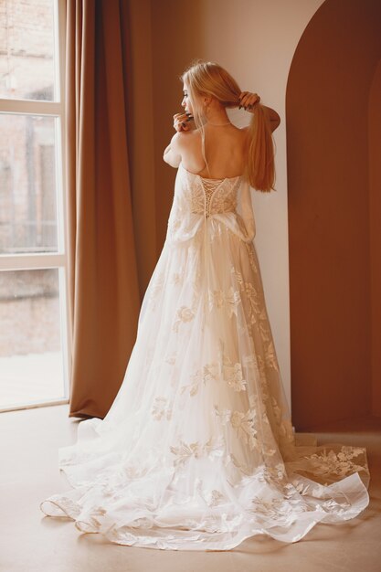 Красивая модель с свадебным макияжем и прической в свадебном кружевном платье.