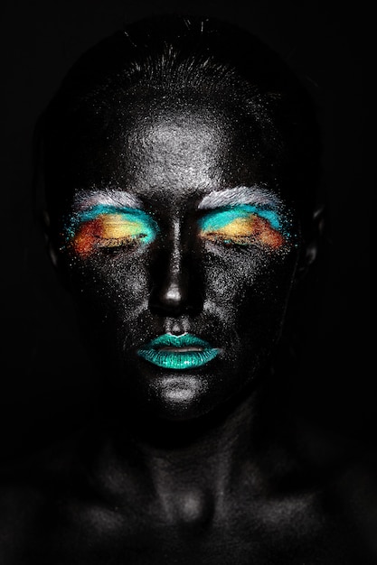 Foto gratuita donna bellissima modella con creativo maschera in plastica nera insolita brillante trucco colorato con la faccia nera