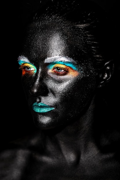 Foto gratuita donna bellissima modella con creativo maschera in plastica nera insolita brillante trucco colorato con la faccia nera