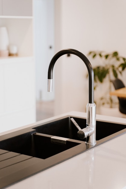 Beautiful modern style faucet with steel sink in the kitchen