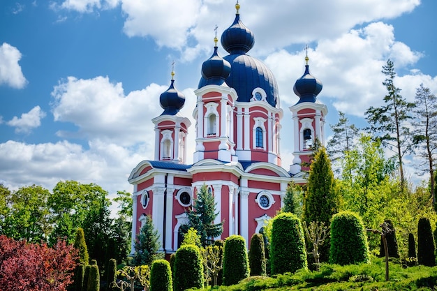 The beautiful Moldavian landmark Curchi Monastery seen behind the green plants in daylight