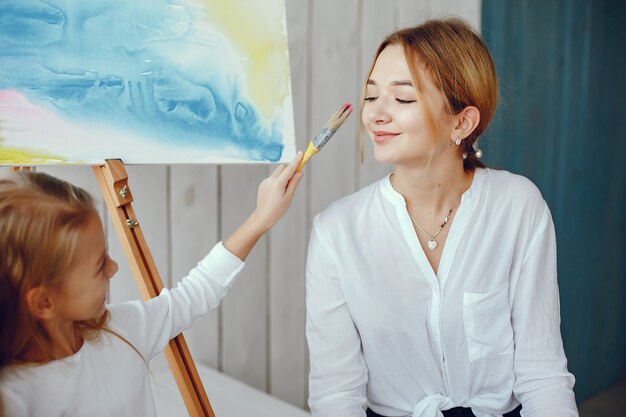 Beautiful mom and daughter are drawing