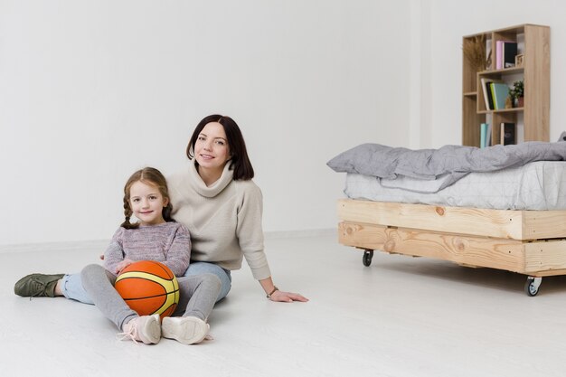 Beautiful mom and daughter posing indoors