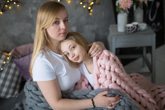 Beautiful mom hugs and gently strokes daughter