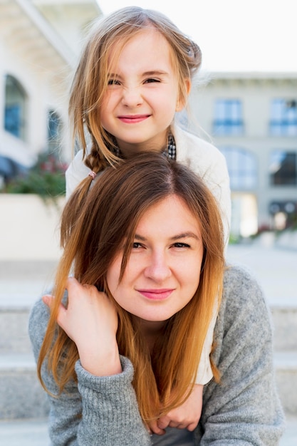 Free photo beautiful mother carrying girl on shoulders