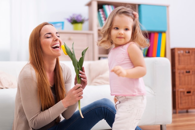 Beautiful mother enjoying the flower which she received from daughter