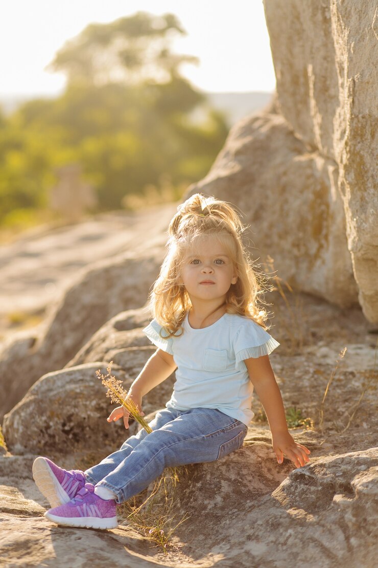 Free Photo beautiful mother and her cute long haired daughter are walking on meadow of stone