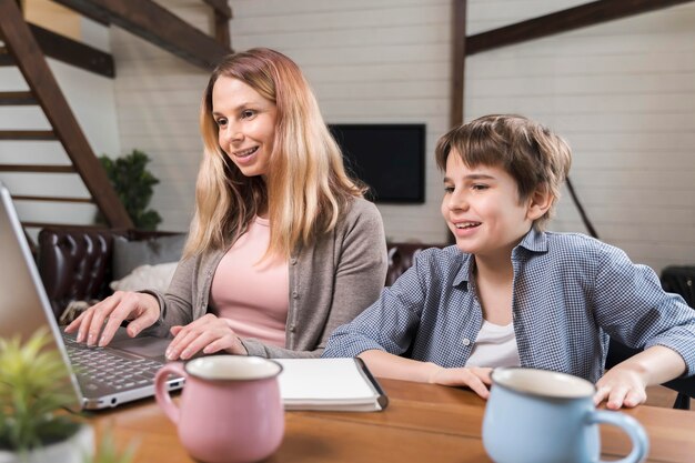 Beautiful mother is working next to her son