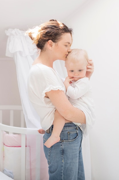 Beautiful mother kissing her baby girl