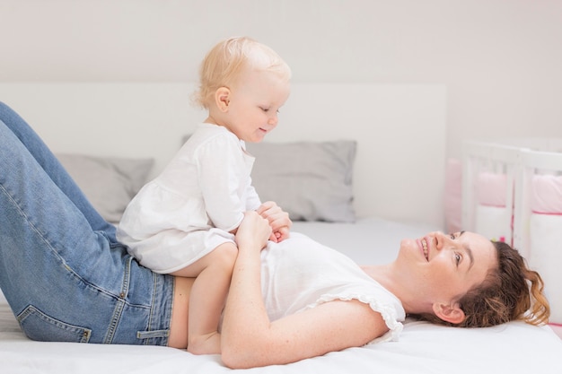 Beautiful mother playing with cute baby girl