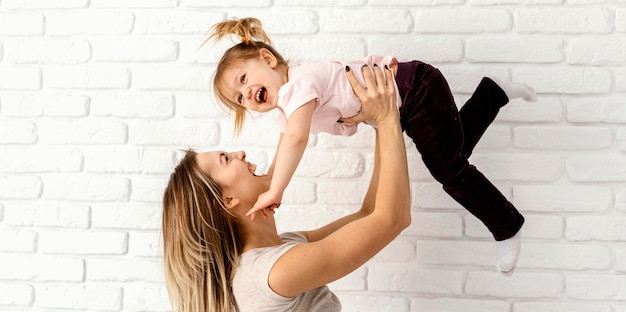 Beautiful mother playing with her daughter at home