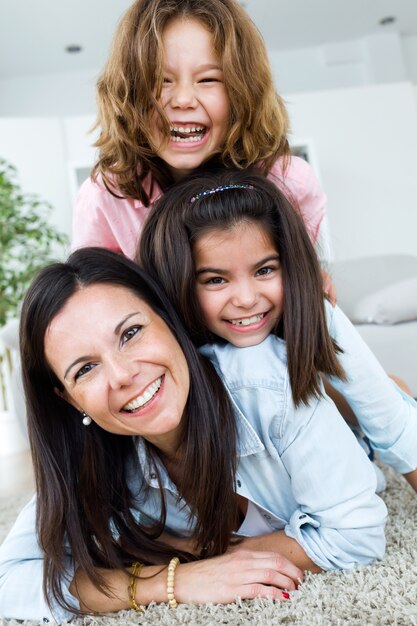 Beautiful mother with her daughters looking at camera at home.