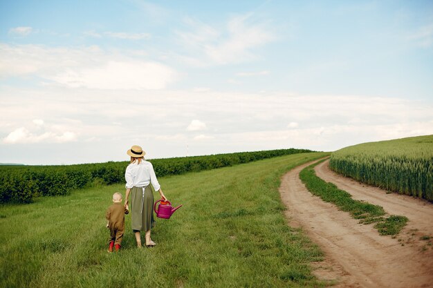 Beautiful mother with little son in a summer field