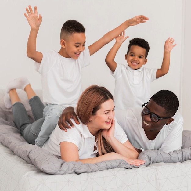 Beautiful multicultural family staying in bed