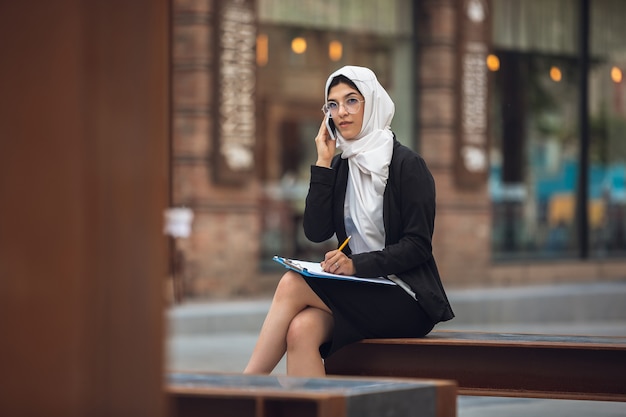 Бесплатное фото Красивый мусульманский успешный портрет деловой женщины уверенно счастливый генеральный директор