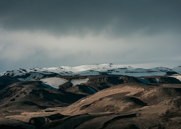 雪に覆われた丘と暗い灰色の空の美しい自然の風景