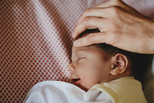 Free photo beautiful newborn child lies on a bed and sleeps