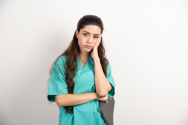 Beautiful nurse portrait on white wall.