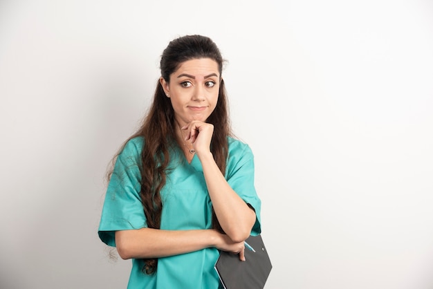 Beautiful nurse portrait on white wall.