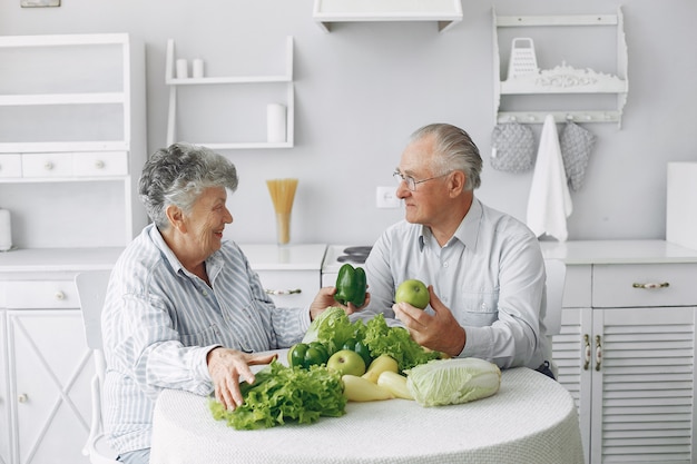 Le belle vecchie coppie preparano l'alimento in una cucina