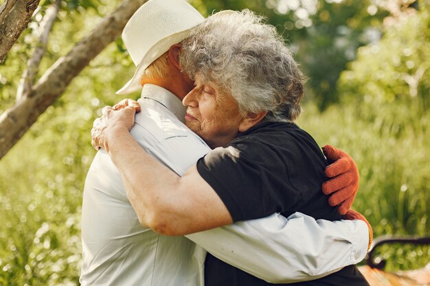 Beautiful old couple spend time in a summer garden