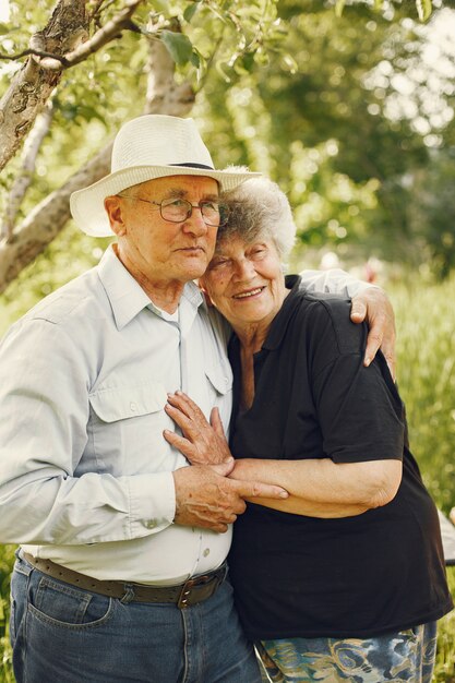 Beautiful old couple spend time in a summer garden