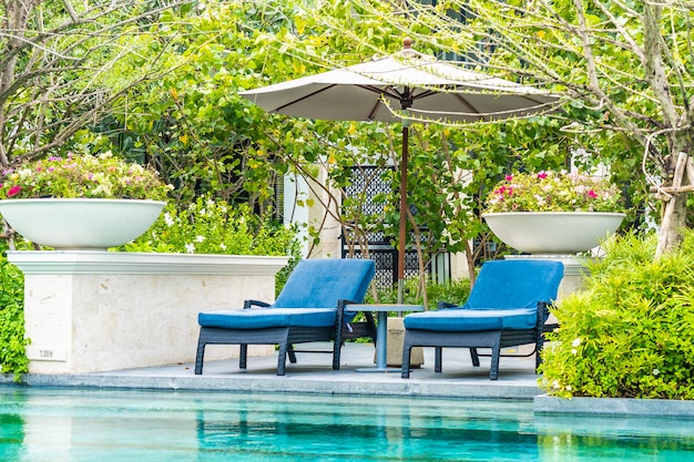 Красивый открытый бассейн в отеле и курорте с креслом и террасой для отдыха