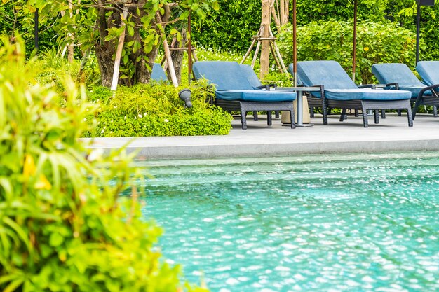 Красивый открытый бассейн в отеле и курорте с креслом и террасой для отдыха