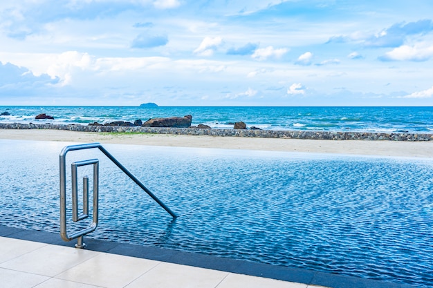 여가를 위해 흰 구름과 푸른 하늘이있는 호텔 리조트의 아름다운 야외 수영장