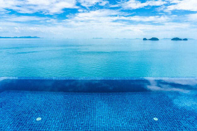 Красивый открытый бассейн с морем океан на белом облаке голубое небо