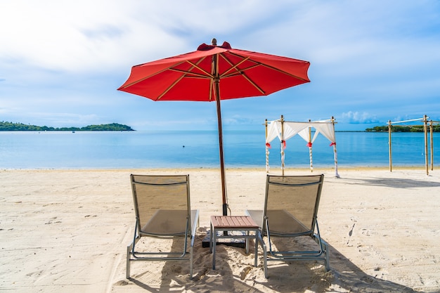 Beautiful outdoor tropical beach sea ocean with umbrella chair and lounge deck around there on white cloud blue sky