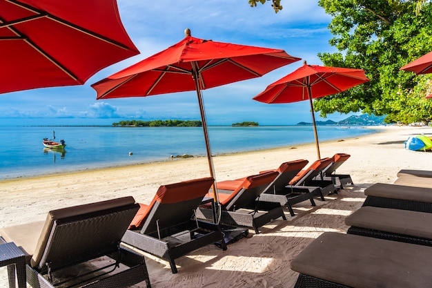 白い雲青い空の上の周りの傘の椅子とラウンジデッキの美しい屋外熱帯ビーチ海