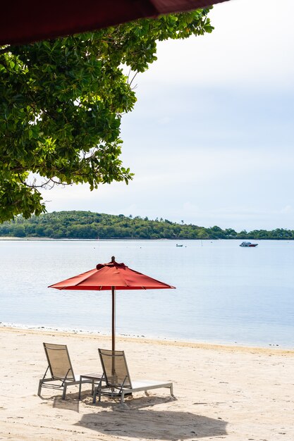 흰 구름 푸른 하늘에 우산 의자와 라운지 갑판과 아름다운 야외 열대 해변 바다 바다