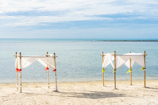 흰 구름 푸른 하늘에 우산 의자와 라운지 갑판과 아름다운 야외 열대 해변 바다 바다