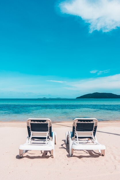 Красивый открытый вид с зонтиком и стулом на пляж и море